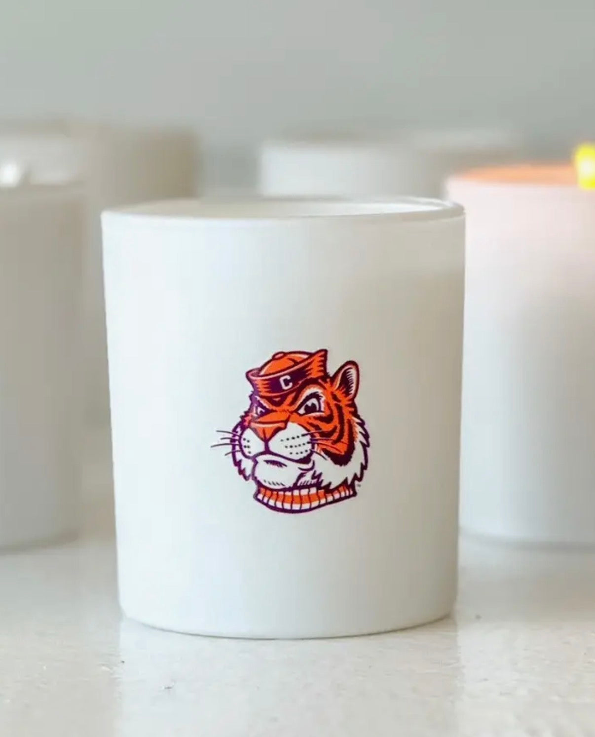 White candle with a tiger design on a white surface