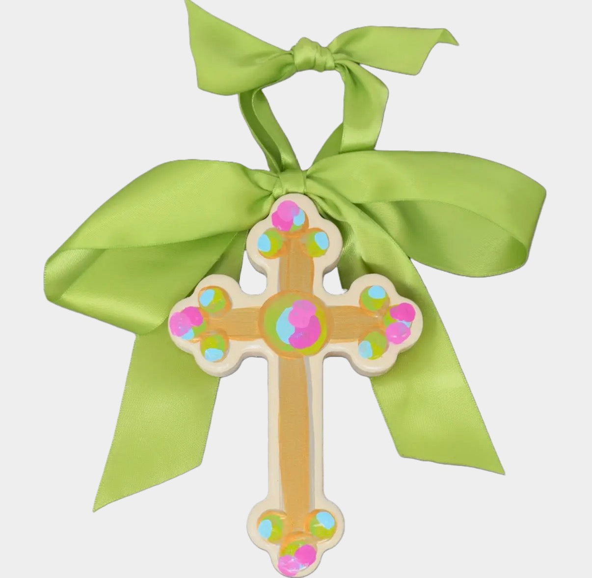 Decorative cross with colorful design and green ribbon on a white background