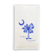 White towel with blue palm tree and moon design on a white background