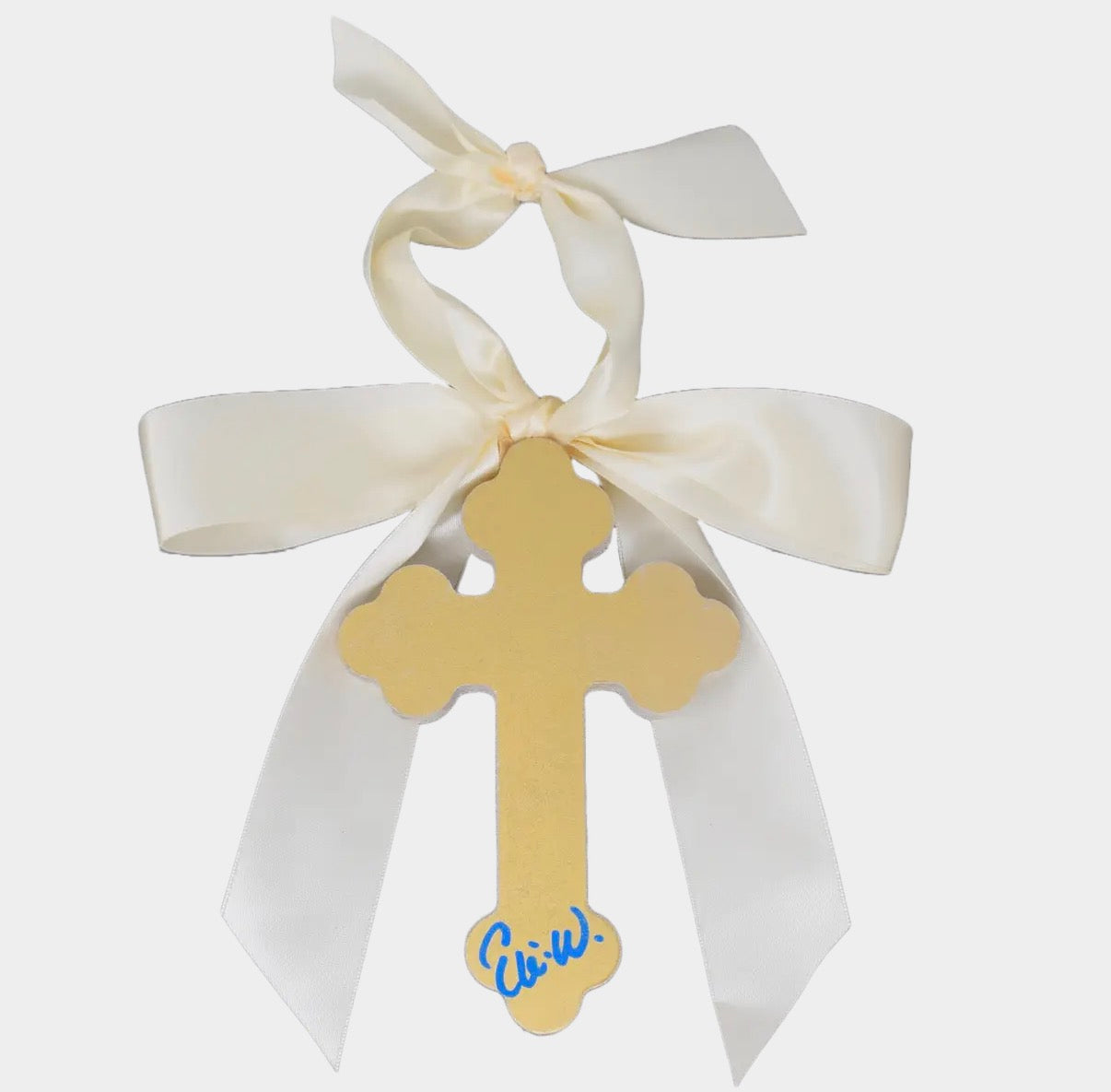 Gold cross with a white ribbon on a light gray background