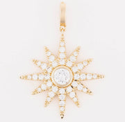 Gold star-shaped pendant with clear stones on a white background