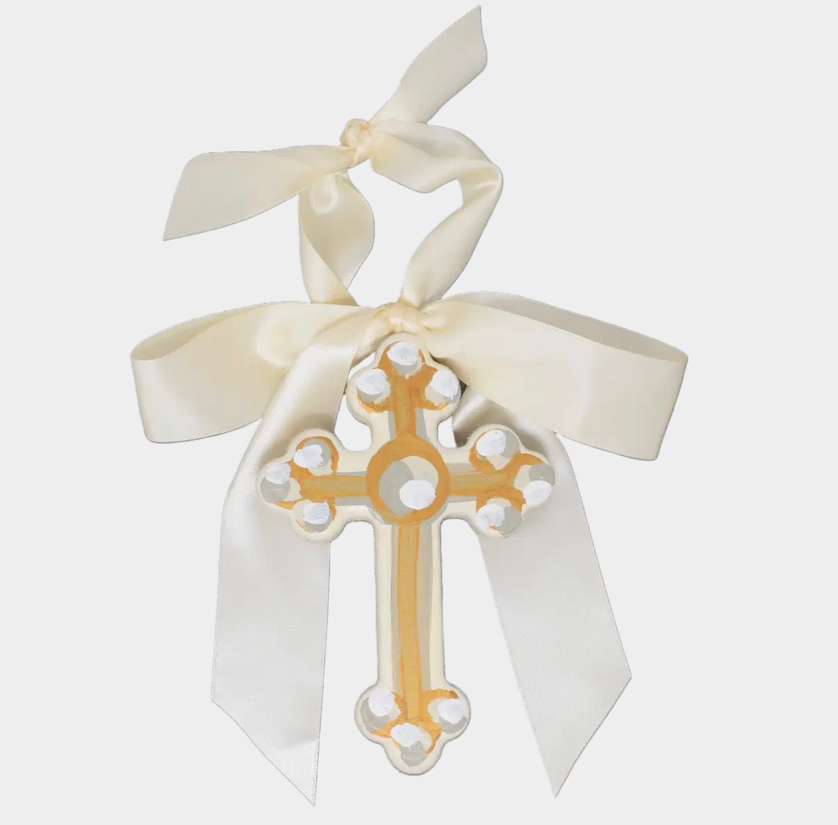 Decorative cross with white ribbon on a light gray background