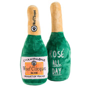 Two plush champagne bottle toys with 'Woof Clicquot' branding on a white background