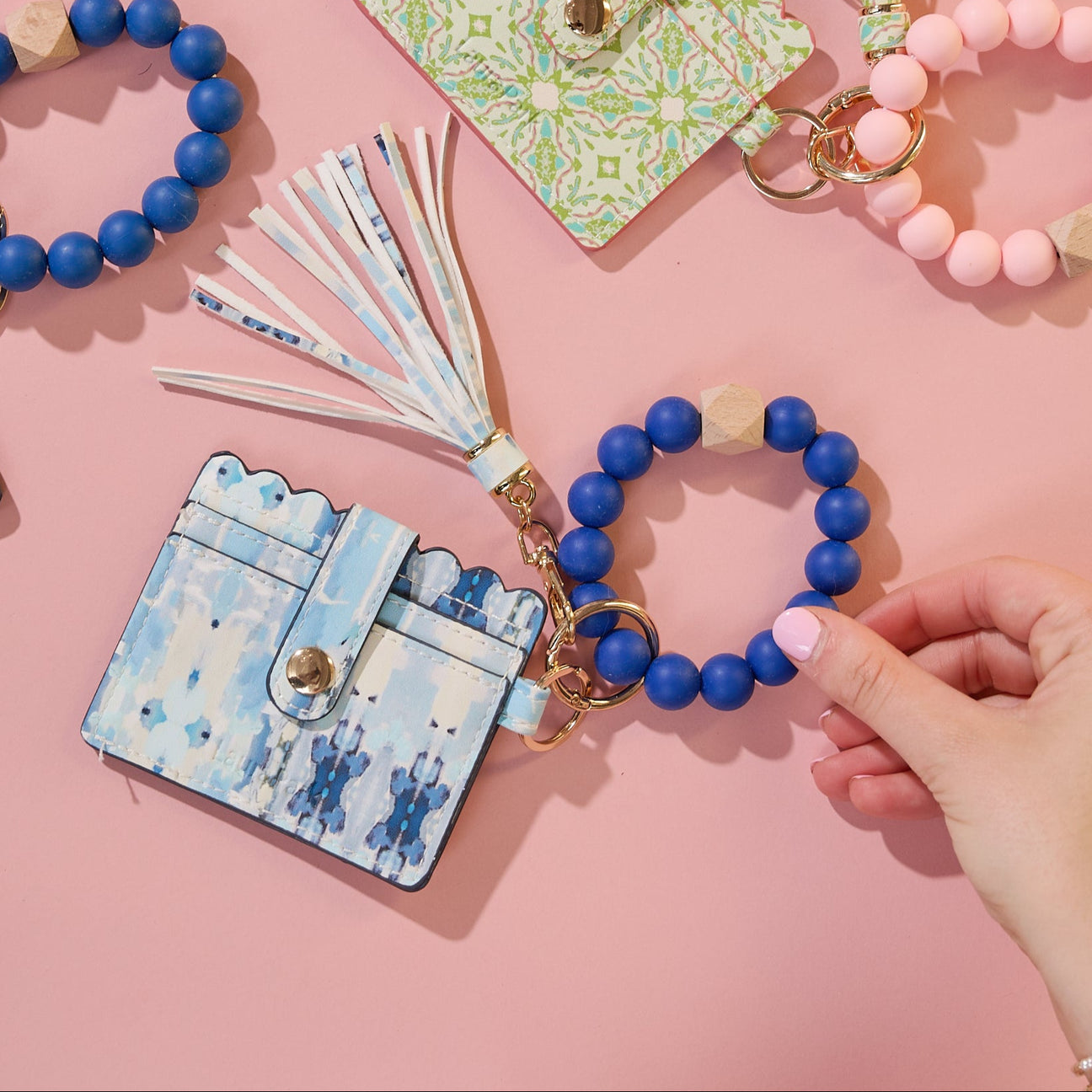 Blue beaded bracelet with a matching keychain on a pink background