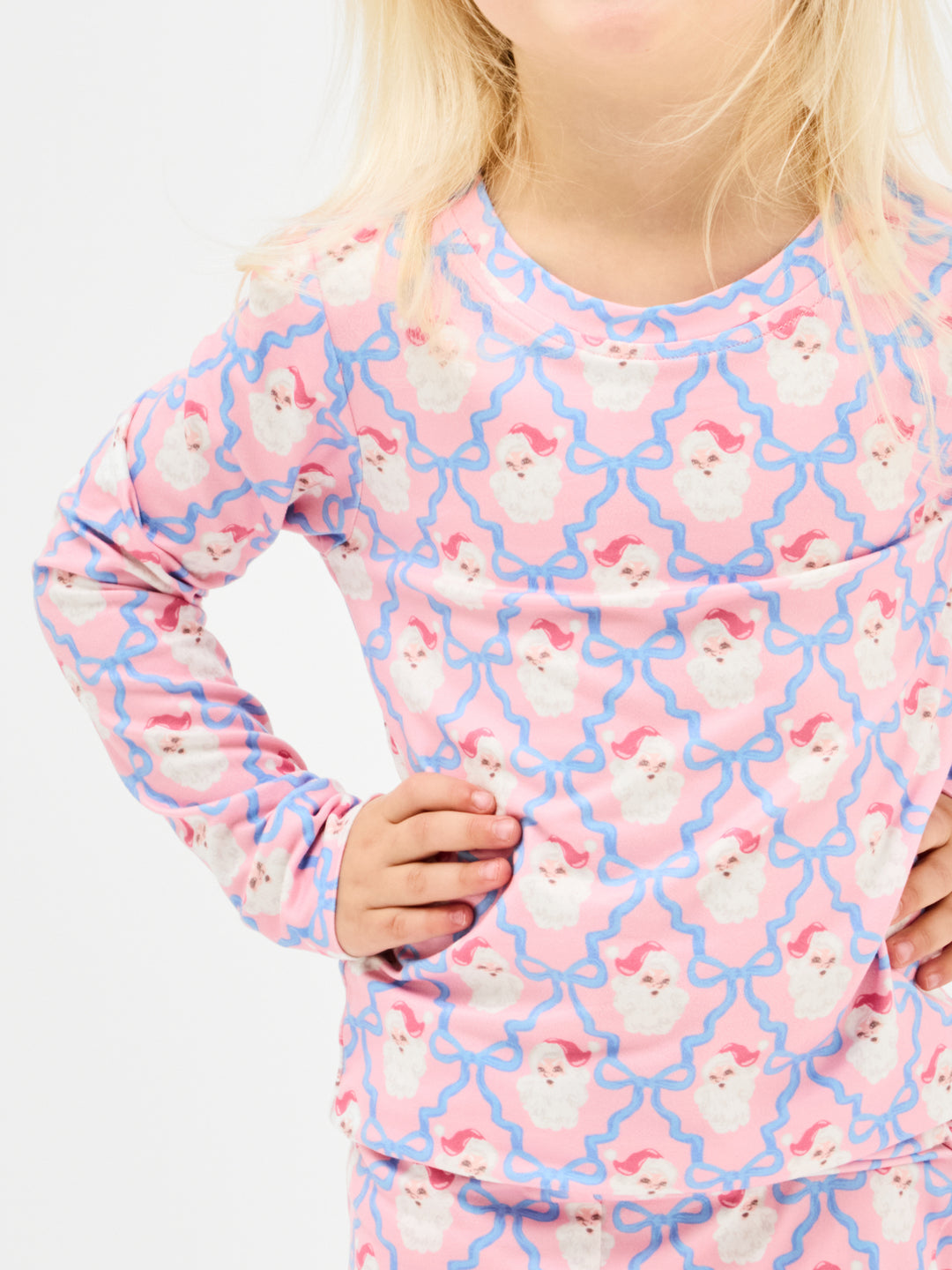 Child wearing a pink and blue patterned long-sleeve shirt with a lattice design.
