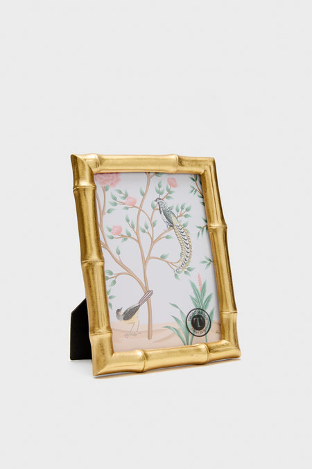 Gold bamboo-style picture frame with a decorative glass cover on a white background