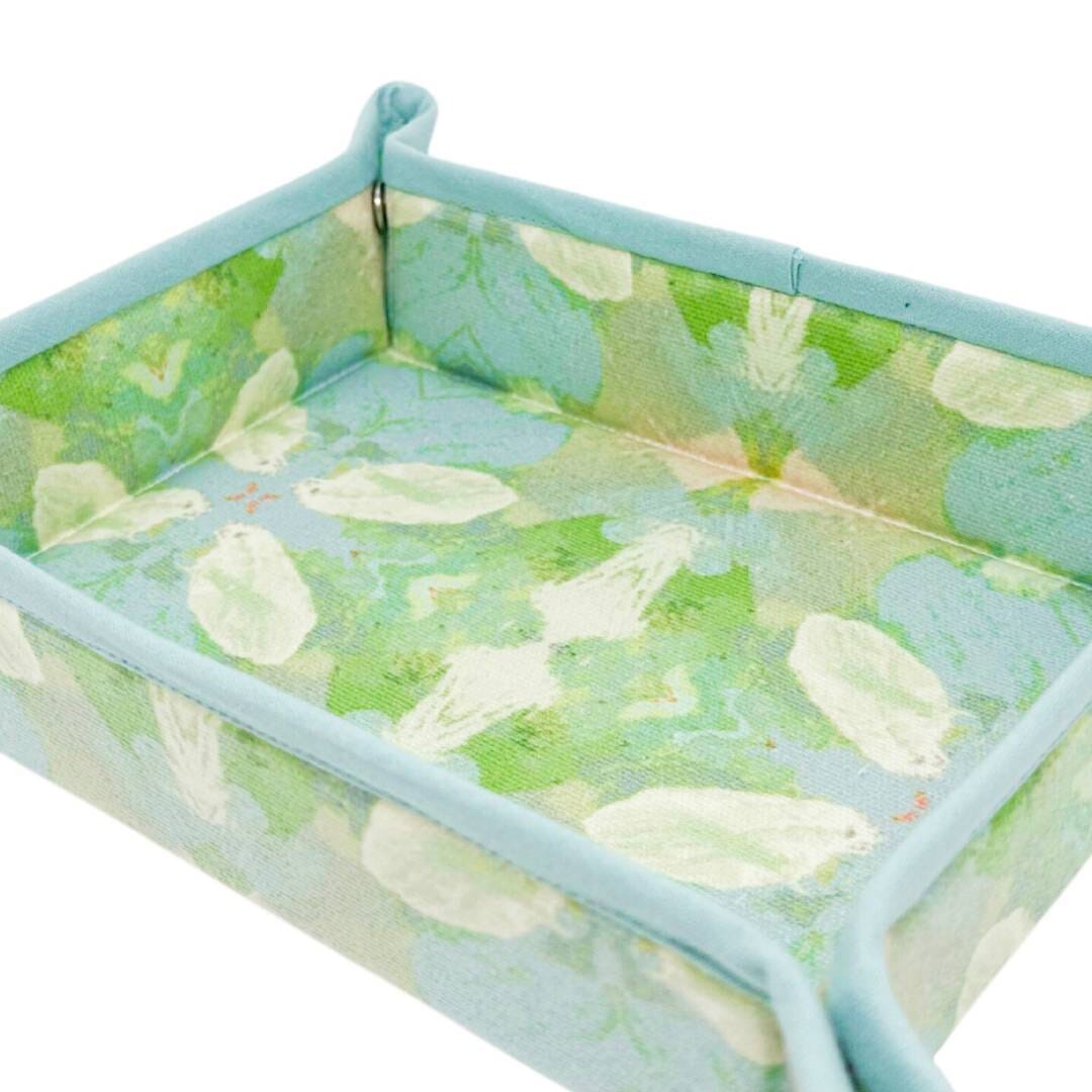 Foldable storage basket with green leaf pattern on a white background