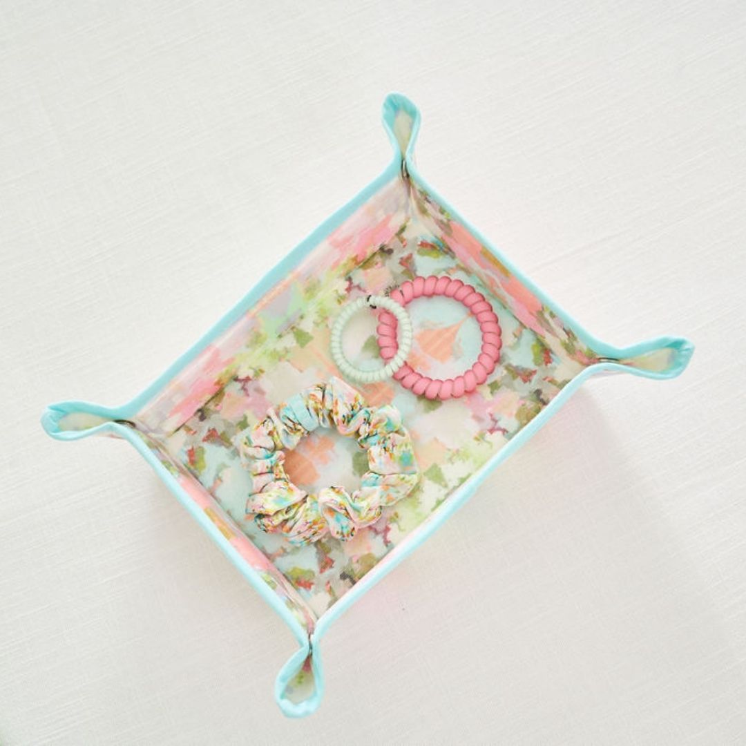 Floral fabric tray with hair ties on a light background