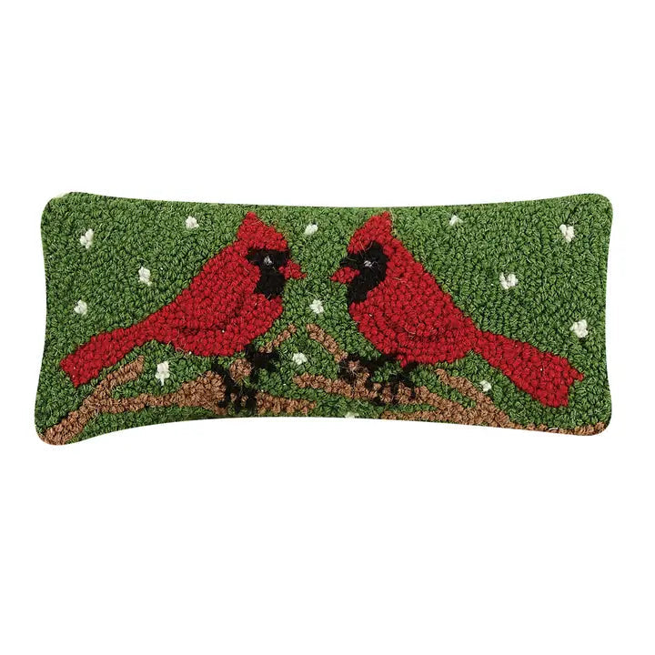 Decorative pillow with red cardinals on a green background