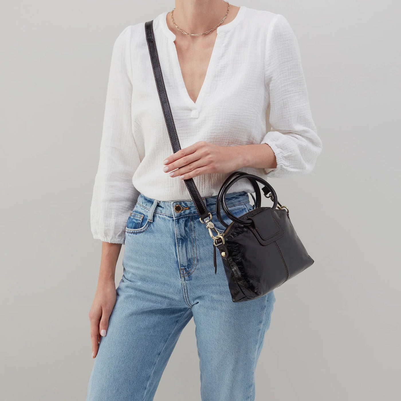 Accessories - Purse - Sheila Top Zip Crossbody - Black crossbody purse being worn by a lady in a white top with jeans on a white background 