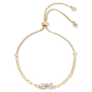 Gold bracelet with bow and crystal details on a white background
