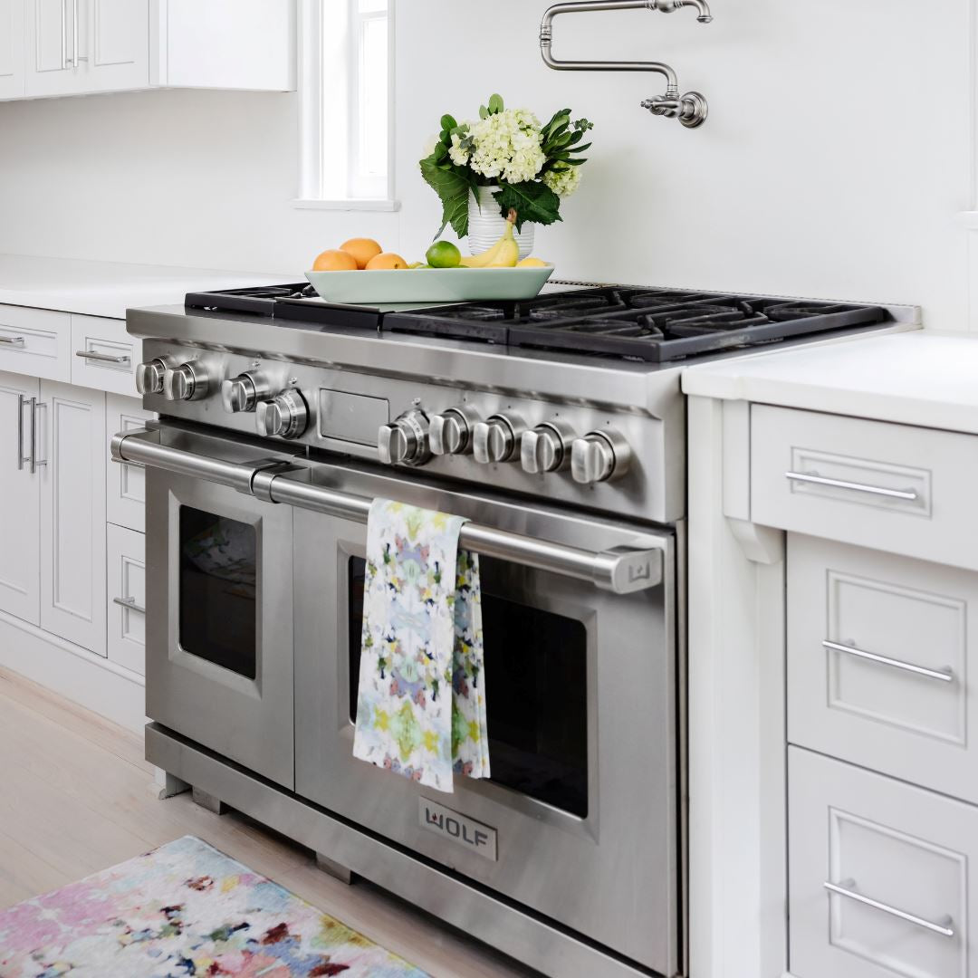 Stainless steel oven with a Laura Park Lady Bird Tea Towel towel hanging on the handle in a kitchen setting