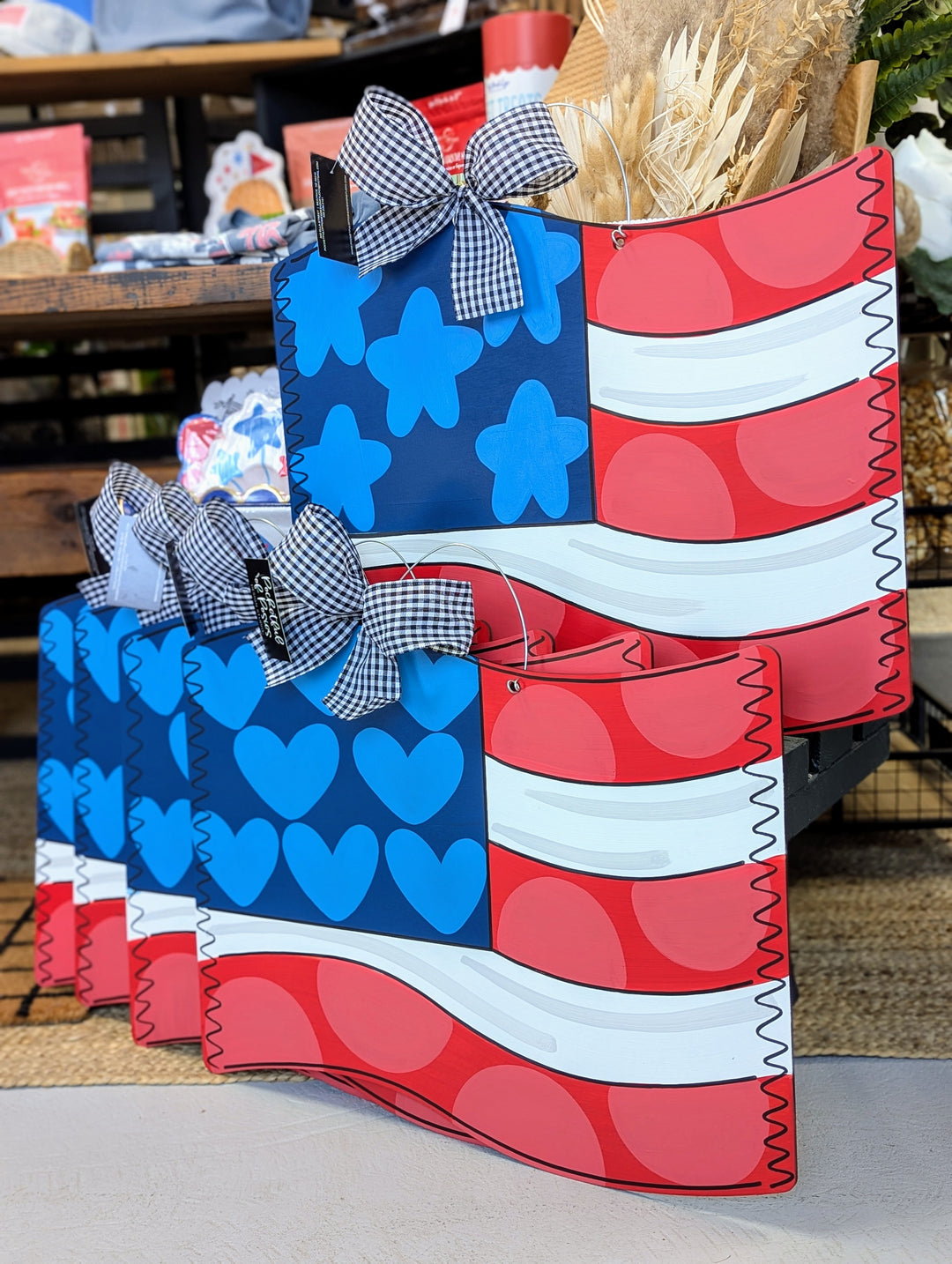 Decorative door hanger shaped like an American flag with blue stars and red, white, and blue patterns.