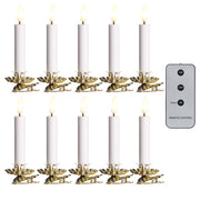 Set of white candles with gold holders and a remote control on a white background