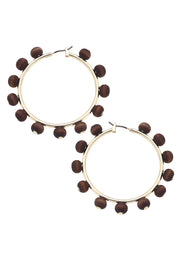 Pair of hoop earrings with brown beads on a white background