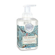 Hand soap bottle with floral design and pump on a white background