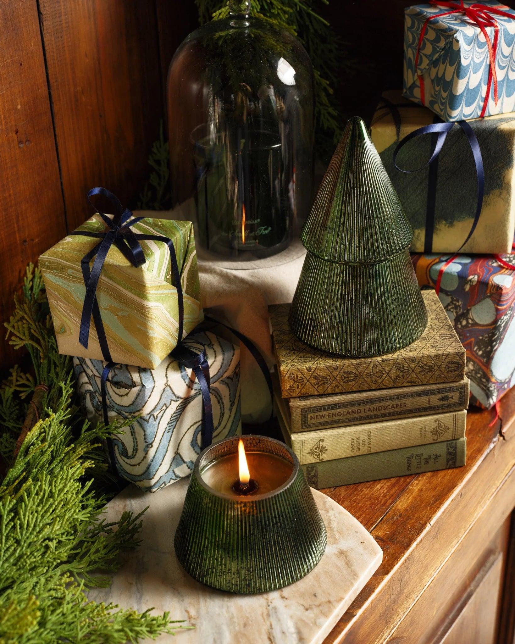 Candle burning on Christmas decorated sofa table 