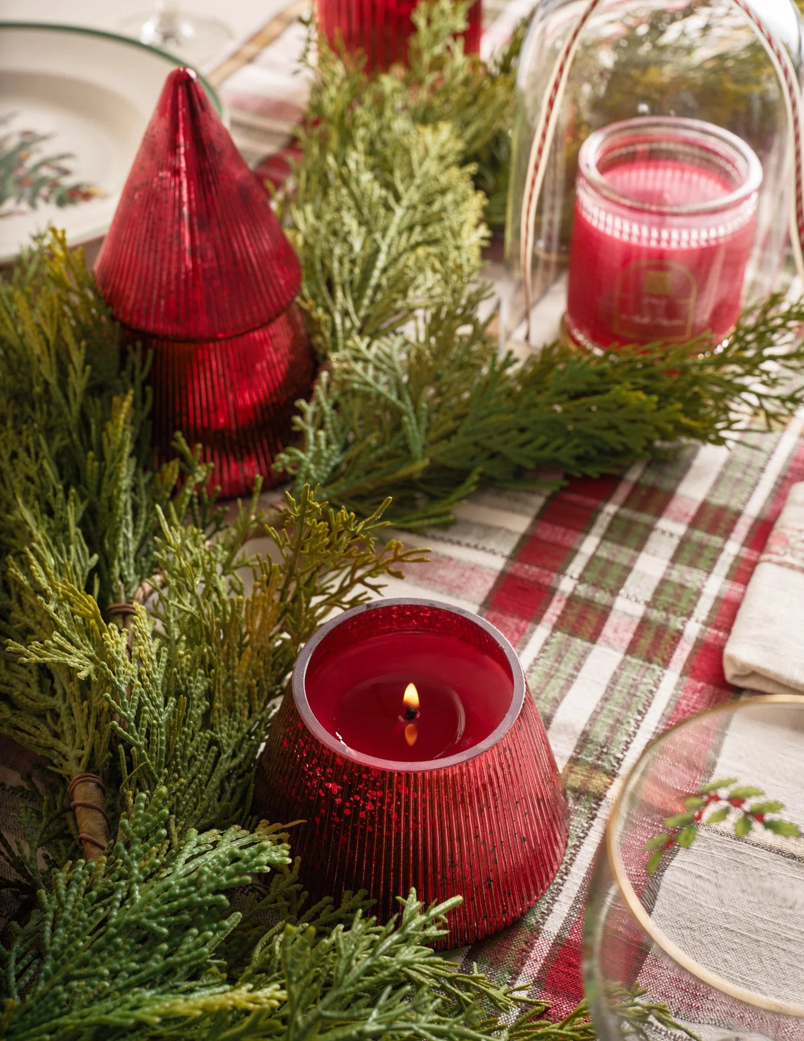 Red tree shaped jar candle on a table with plaid tablecloth 
