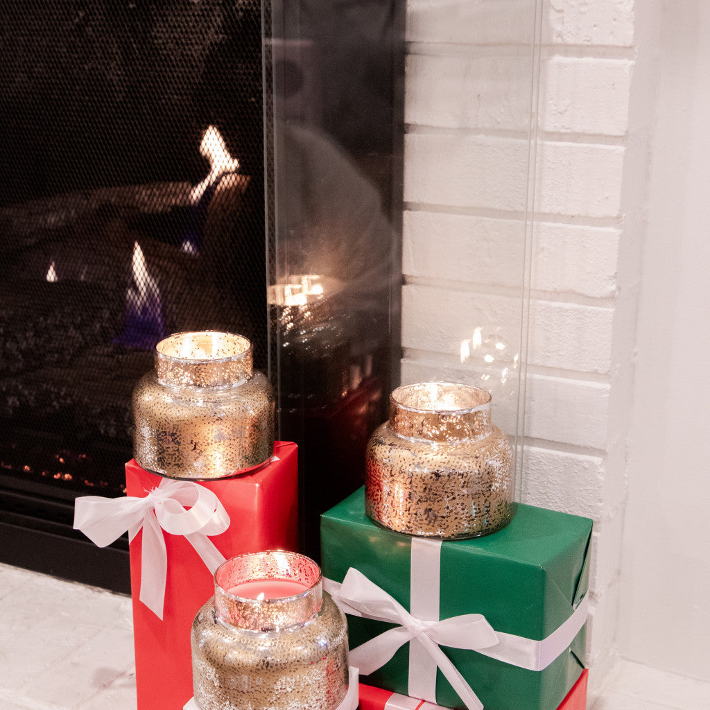 3 lit candles by a fireplace 