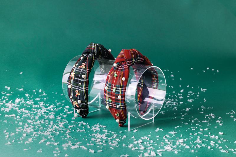 Two plaid dog collars on a green background with decorative snowflakes.