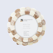 Round photo frame with natural wood and bone design on a light gray background