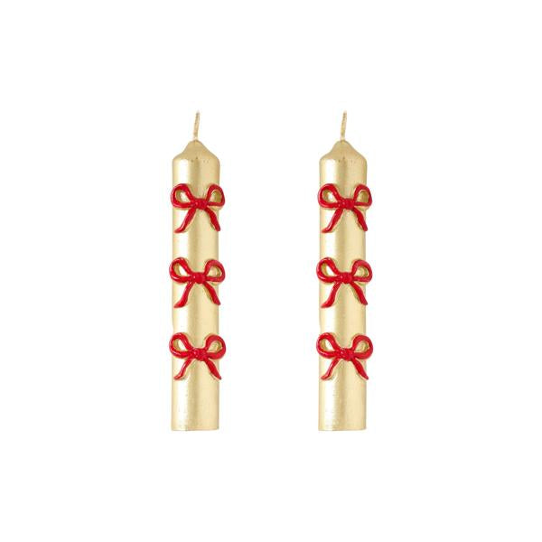 Two gold candles with red bows on a white background
