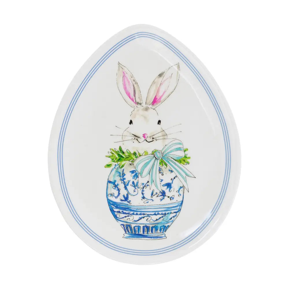 Decorative egg-shaped plate with a bunny and floral design on a white background