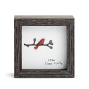 Decorative piece with a red bird on a branch and 'love from above' text in a wooden frame.