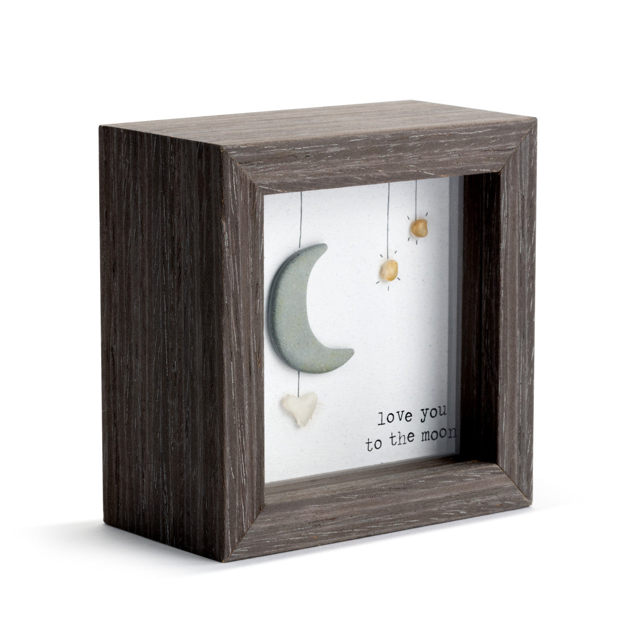 Decorative box with wooden frame containing hanging moon and heart decorations with text.