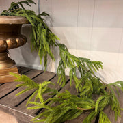 Green decorative garland on a wooden surface with a neutral background