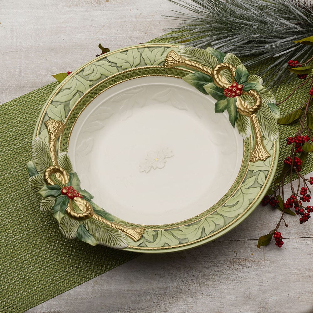 Decorative bowl with greenery and gold accents on a wooden surface