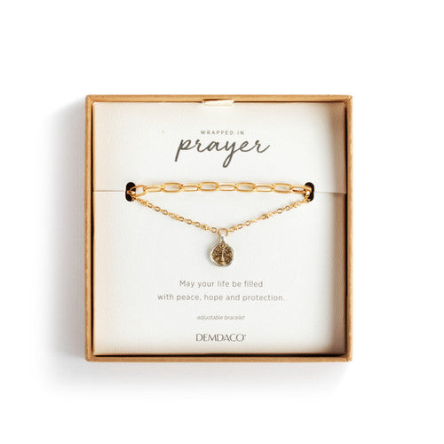 Gold bracelet with a heart charm on a 'Wrapped in Prayer' card by Demiaco.