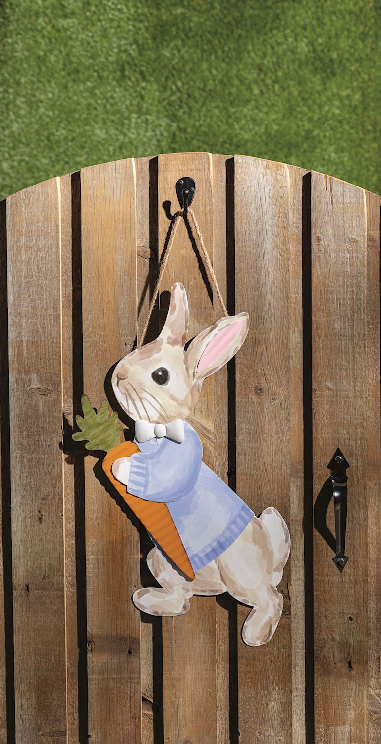 Decorative door hanger of a rabbit holding a carrot on a wooden background