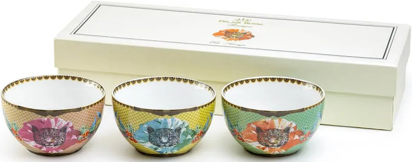 Set of three colorful ceramic bowls with floral patterns in front of a white box.