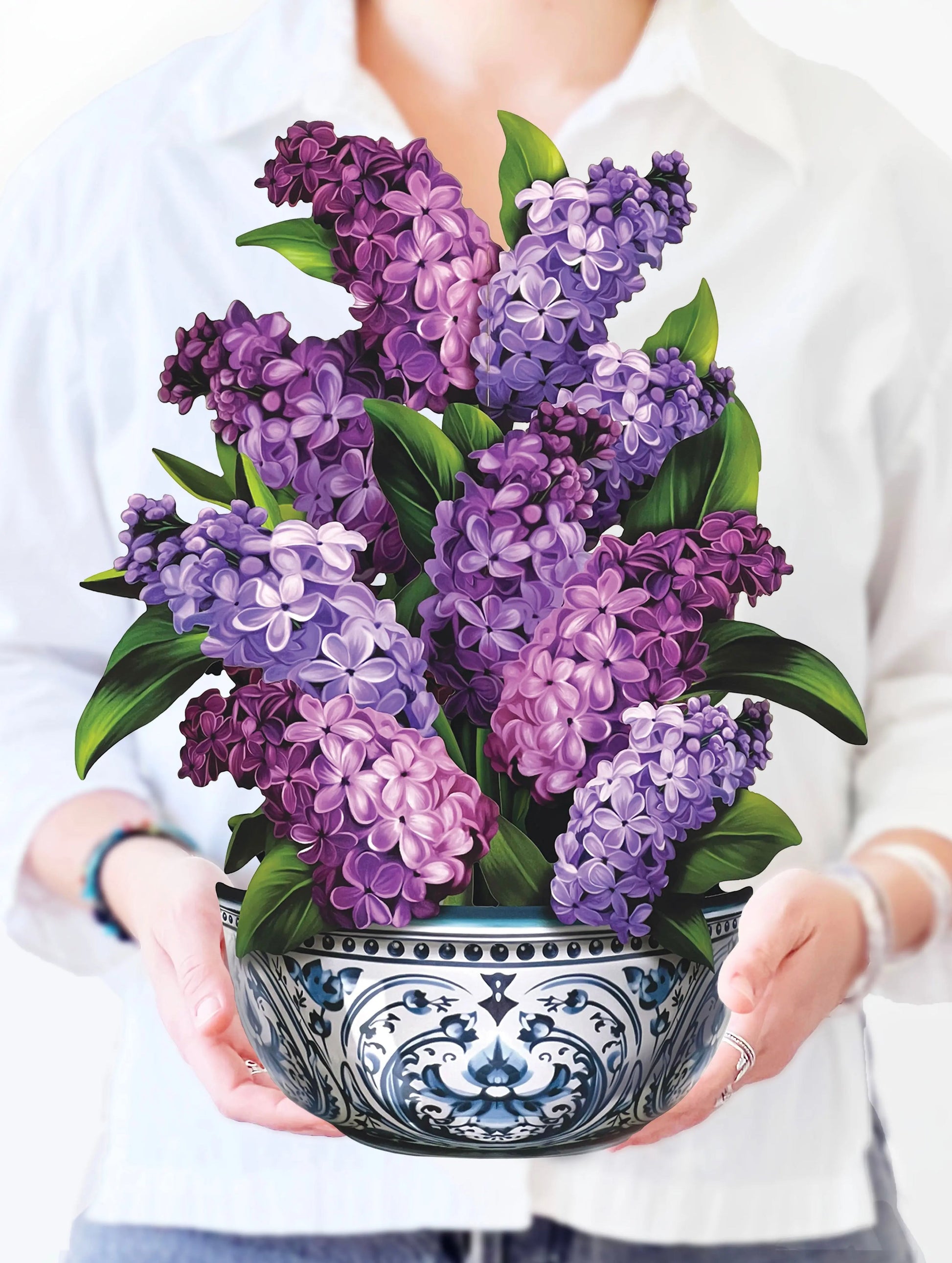 Person holding a bowl of purple flowers