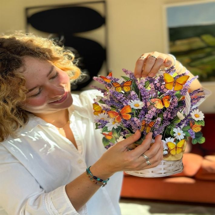 Woman holding a decorative basket with flowers and butterflies