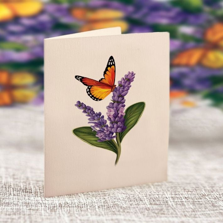 Card with a butterfly and lavender design on a textured surface with blurred floral background