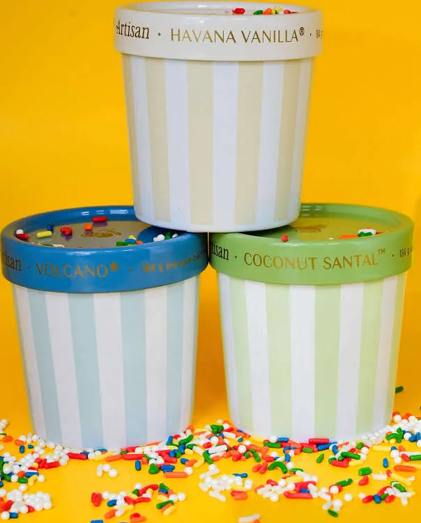 Photo of 3 varieties of candles stacked with sprinkles around them on a yellow background 