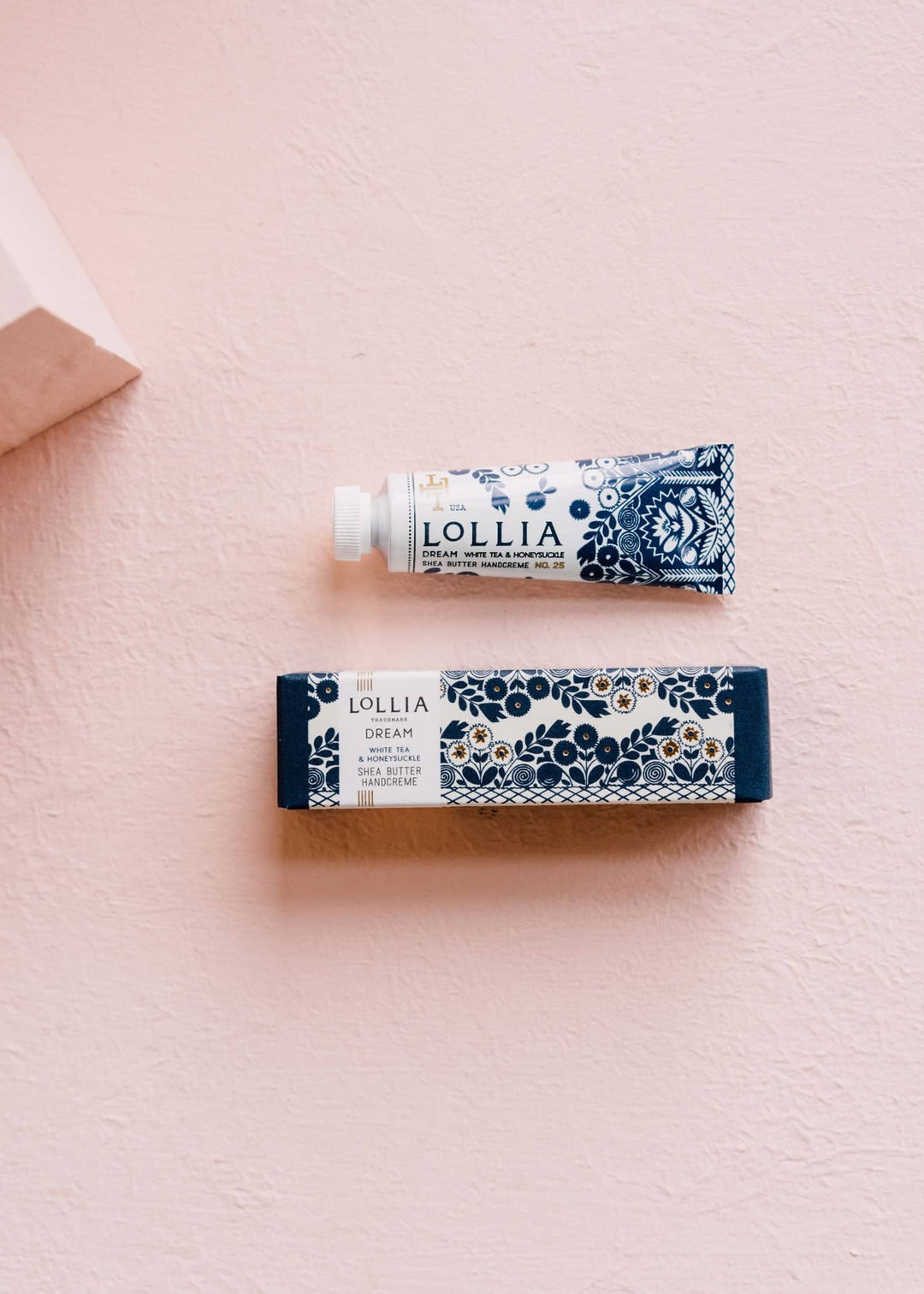 Small dream hand cream and box on a pink background 