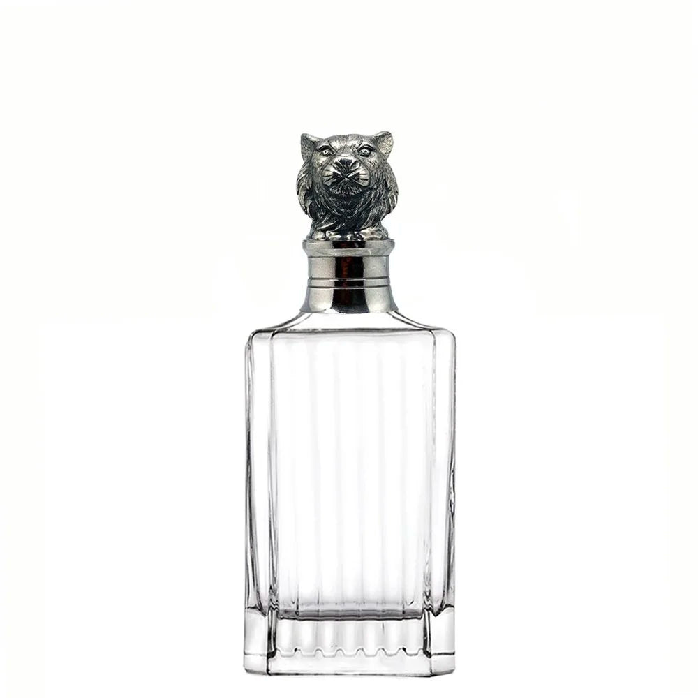 Clear glass decanter with silver owl-shaped stopper on a white background