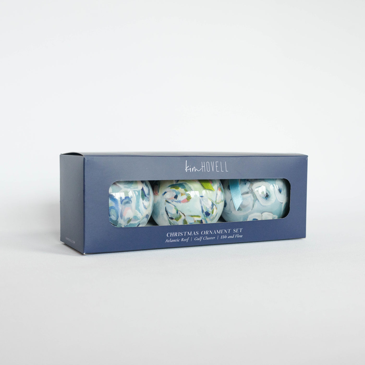 Set of Christmas ornaments in a branded box on a white background
