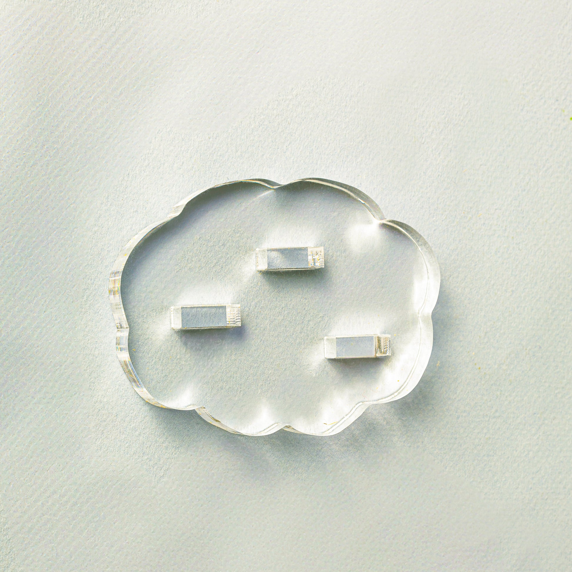 Clear cloud-shaped object with embedded smaller rectangular objects on a light gray background