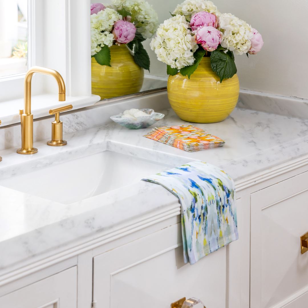 Tea Towel - Wintergreen- this is a picture of the wintergreen colorful design tea towel resting on a kitchen sink, also in the picture is a yellow vase full of flowers 
