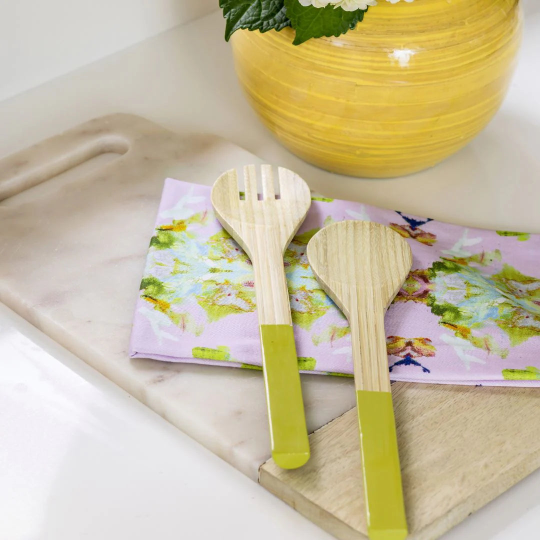 Tea Towel - Stained Glass Lavender- colorful tea towel is seen here with two wooden spoons resting on a cutting board and near a yellow vase on a countertop