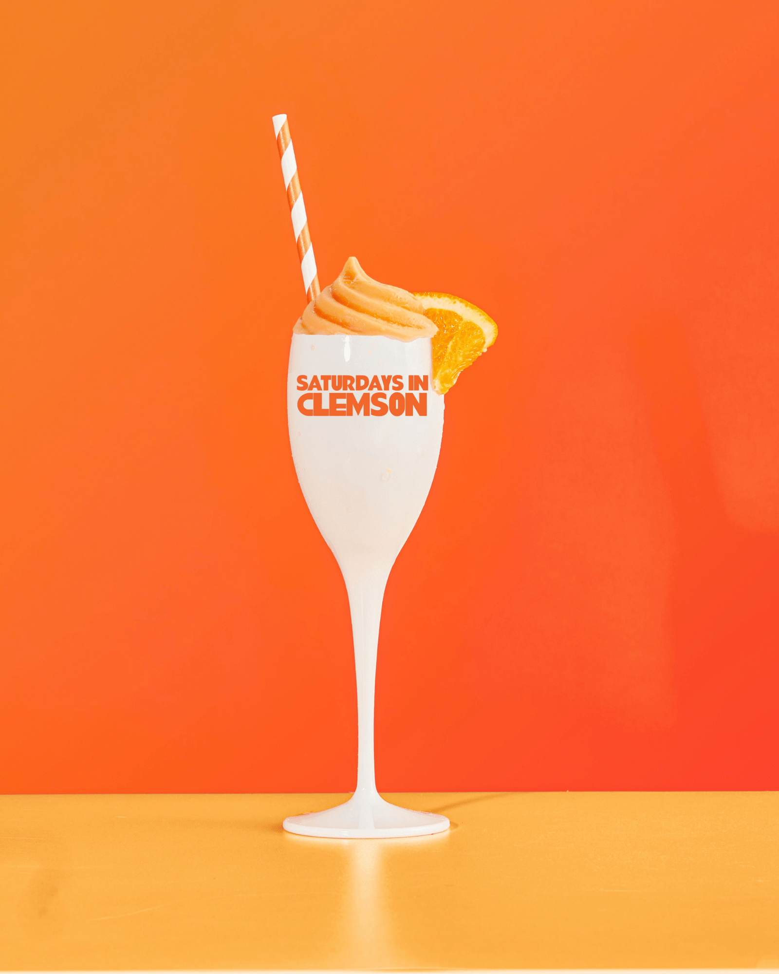 Gameday - Champagne Flute - Acrylic - Saturdays In Clemson- white champagne flute with words Saturdays in Clemson in Orange - with straw and orange background 