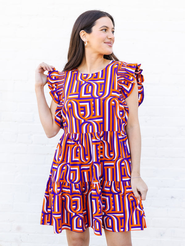 Woman wearing a colorful geometric patterned dress against a white background