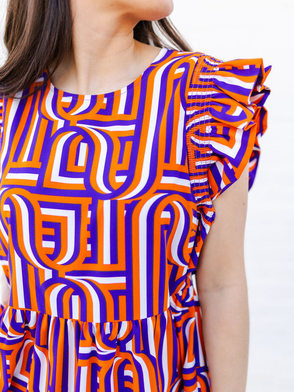 Woman wearing a colorful geometric patterned dress on a white background