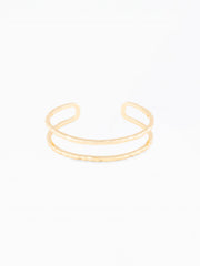 Gold open bangle on a white background