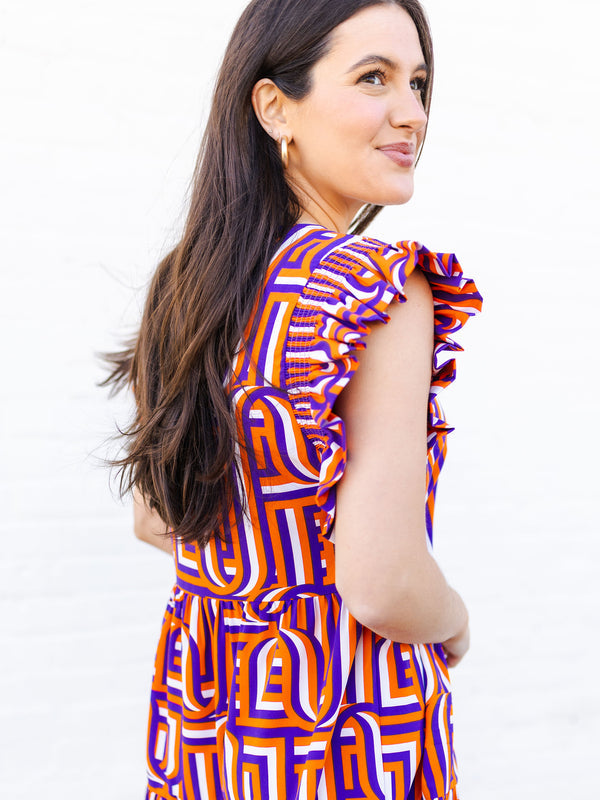 Woman wearing a colorful geometric-patterned dress on a white background