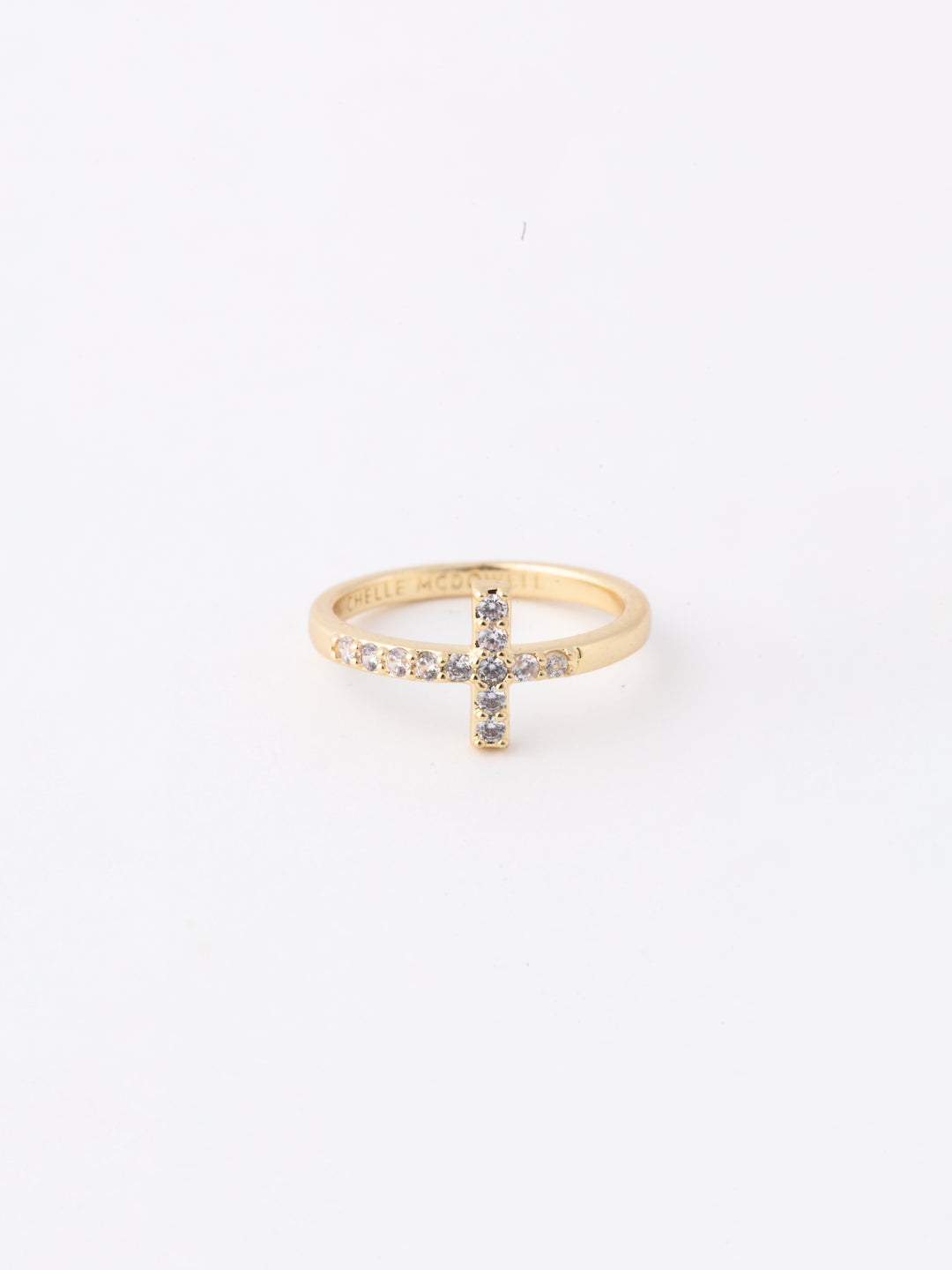 Gold ring with a cross design on a white background